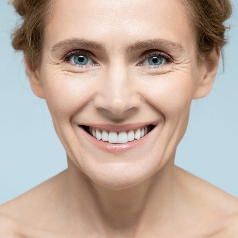 Beauty portrait of middle-age woman with perfect and shiny skin. Concept of skin care and aesthetic cosmetology