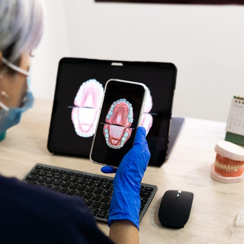 A shallow focus of a female dental technician designing a new dental prosthesis in a clinic